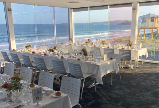 A table set up for a dinner with a view of the ocean in the Sutherland Shire.