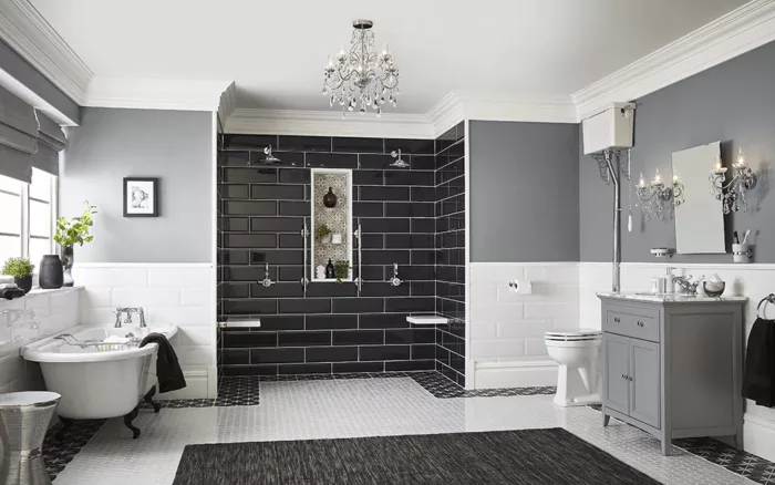 A renovated bathroom featuring black and white tile and a chandelier.