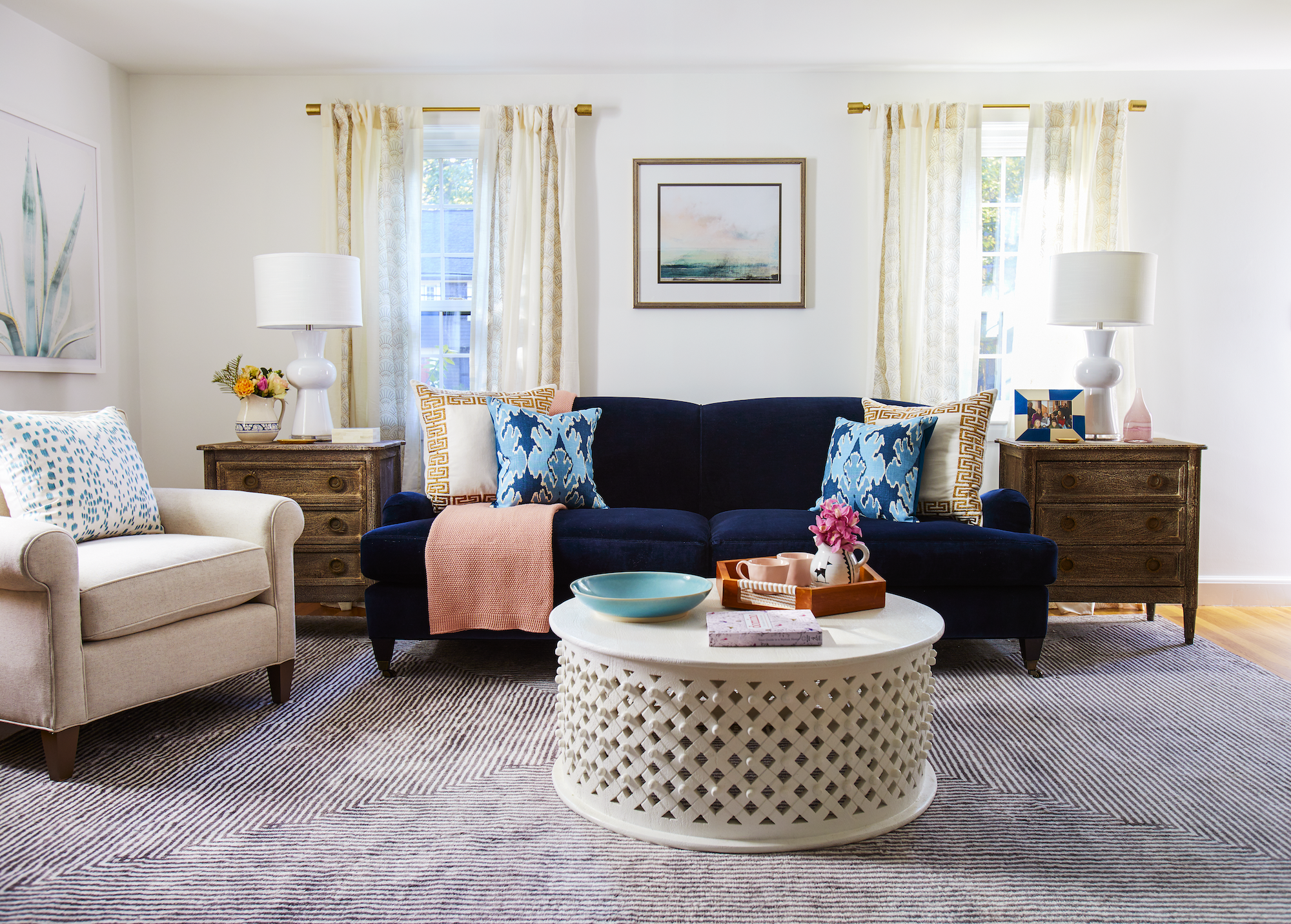A living room featuring a stylish blue couch and a coffee table.