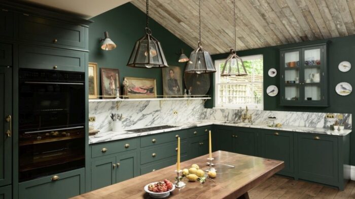 A kitchen with green cabinets and marble counter tops showcases the latest Kitchen Design Trends.