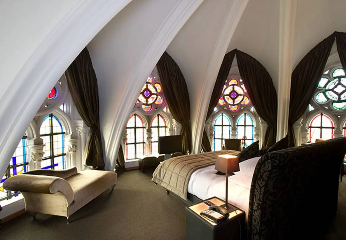 A Victorian Gothic-inspired bed in a room with stained glass windows.