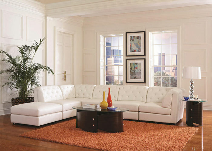 A white sectional sofa with material imitations in a living room.