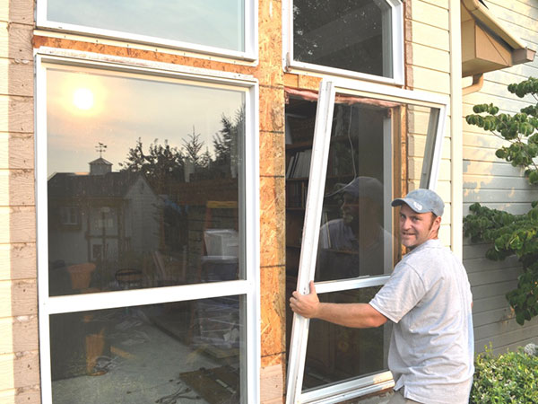A man replacing windows in a house.