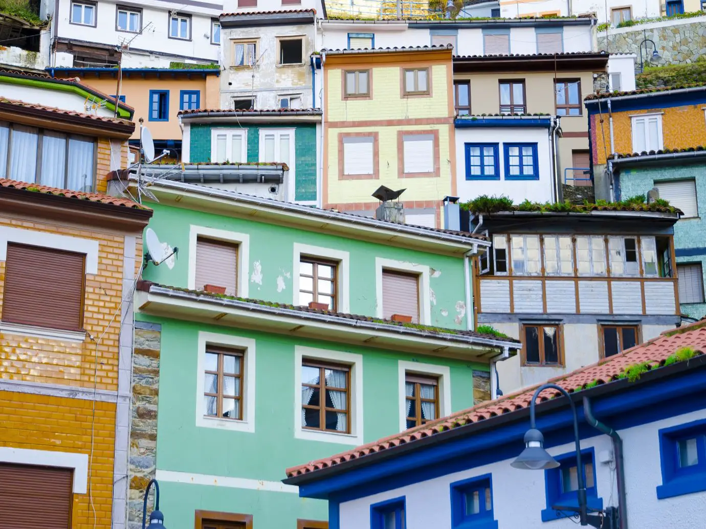 Colorful houses showcasing Spanish architectural features on a hillside.