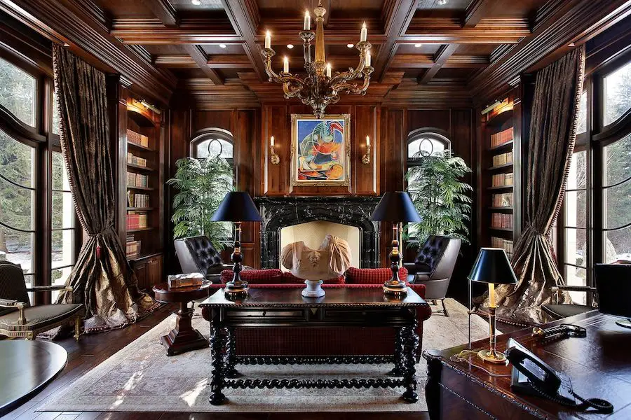 A Victorian Gothic-inspired home office with a fireplace and wood paneled walls.