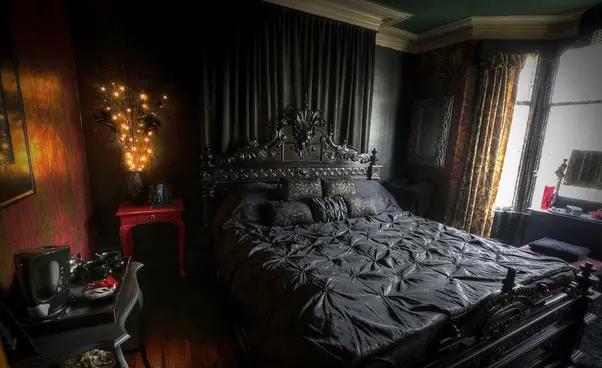 A Victorian Gothic-inspired bedroom with a bed and a dresser.