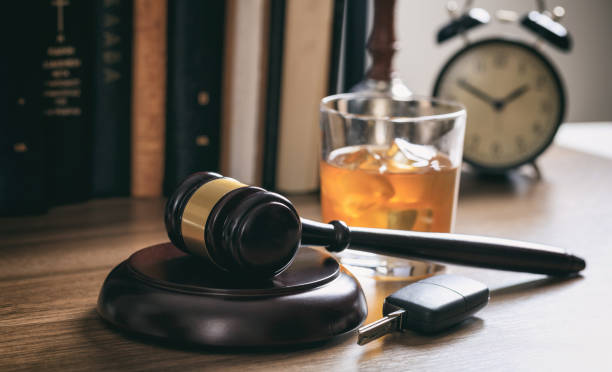 DUI concept. Law gavel, alcohol and car keys on a wooden desk.
