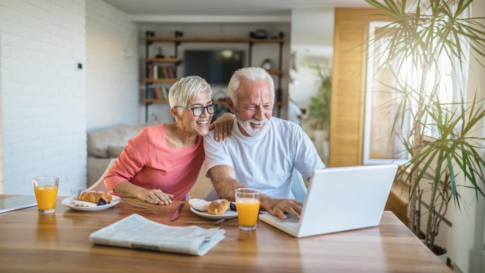 An older couple using a laptop for home improvements.