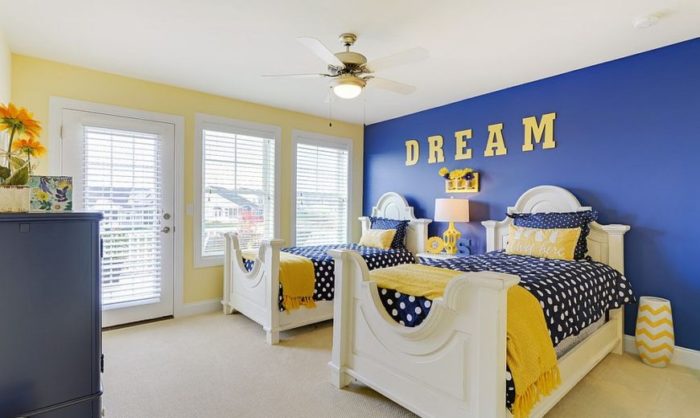Two beds in a blue and yellow teenagers' bedroom.