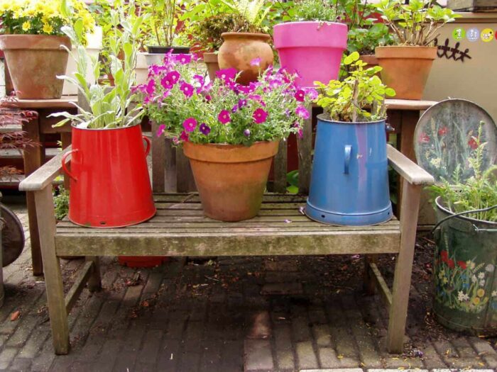 A recycled wooden bench with pots in the garden.