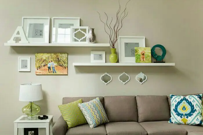 A decorated living room with a couch and a few pictures on the wall.