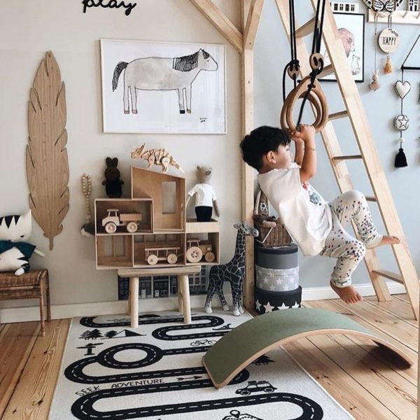 A child's playroom with a wooden swing and a rug is decorated.
