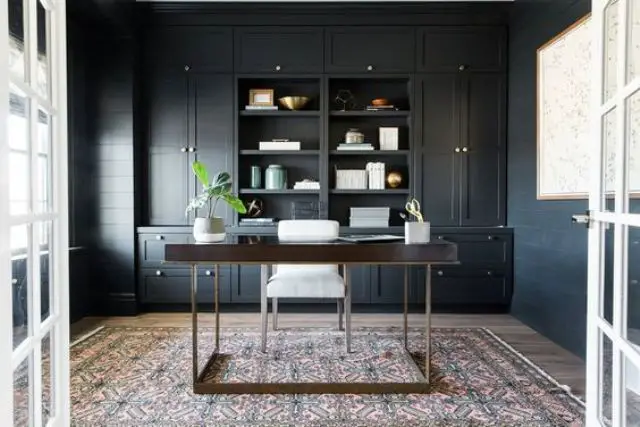 A home office with black cabinets for managing work.
