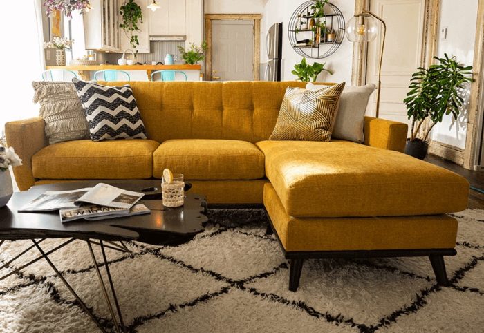 A living room with a yellow couch and coffee table.