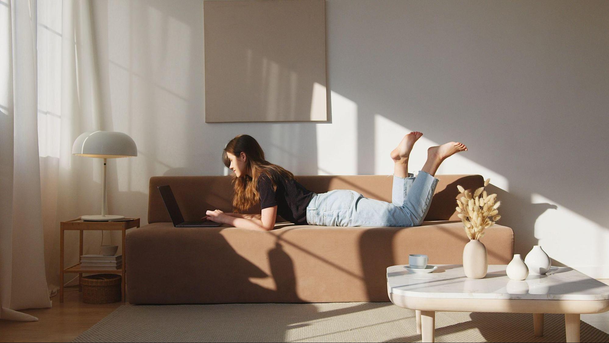 A woman lounges on a chic couch in a trendy living room.