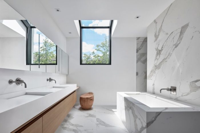 A modern bathroom with marble floors and a skylight showcasing contemporary design styles.
