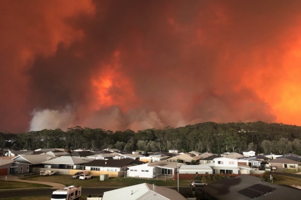 A bushfire threatens a residential area.