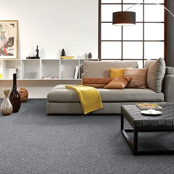A living room with gray carpeted flooring and furniture, showcasing some interior design mistakes.