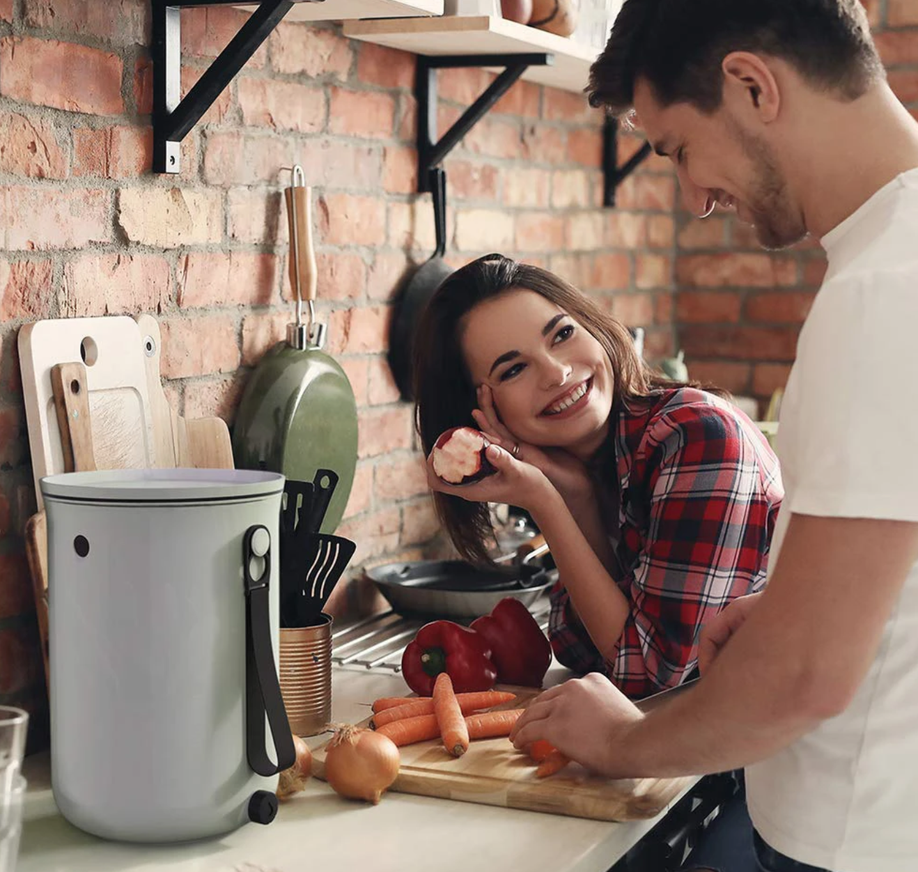 A man and woman are composting in a kitchen using bokashi.