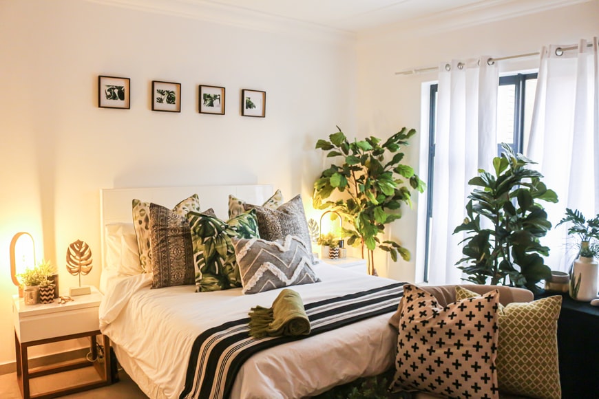 A stylish bedroom with a bed and plants.