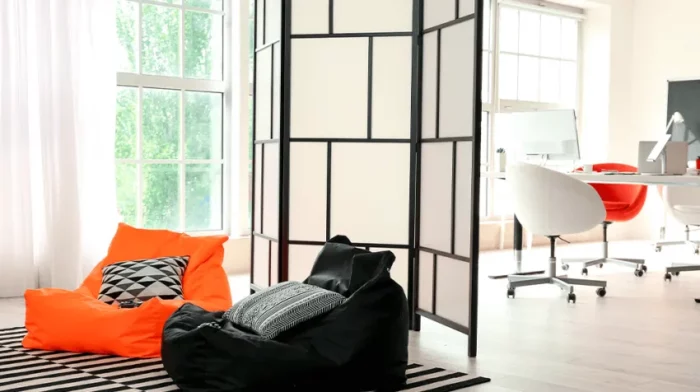 A modern office with an orange bean bag chair.