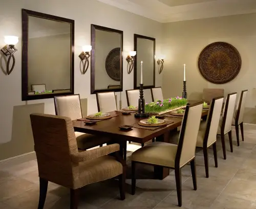 A dining room with a large table, chairs, and a mirror.