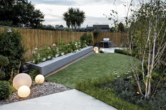 A modern backyard with artificial grass and lights, perfect for a garden during the fall.