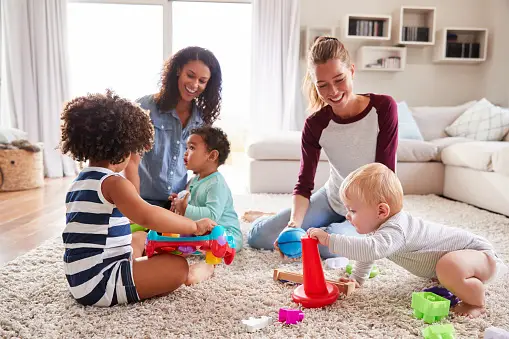 A family decorating the kids' room with toys in a living room.