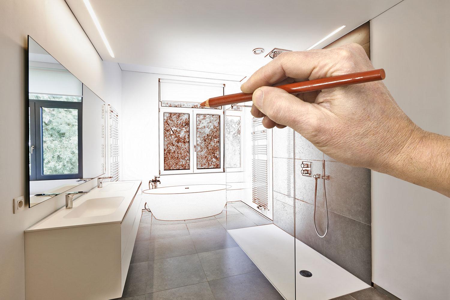 A person sketching a bathroom remodel.