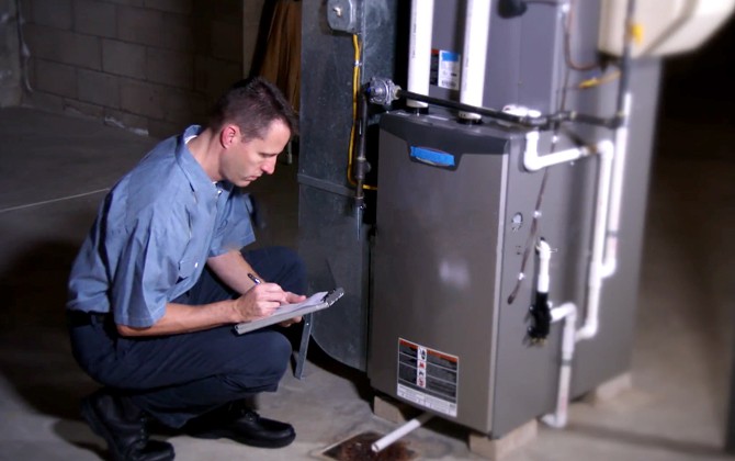 A man inspecting a gas furnace for potential buying.