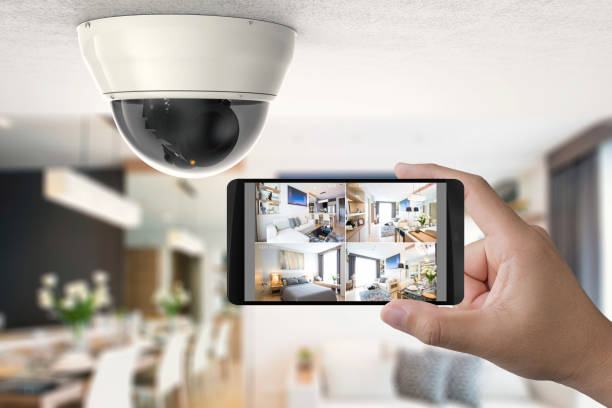 A person holding up a camera to take a picture of a home for reliable home security.