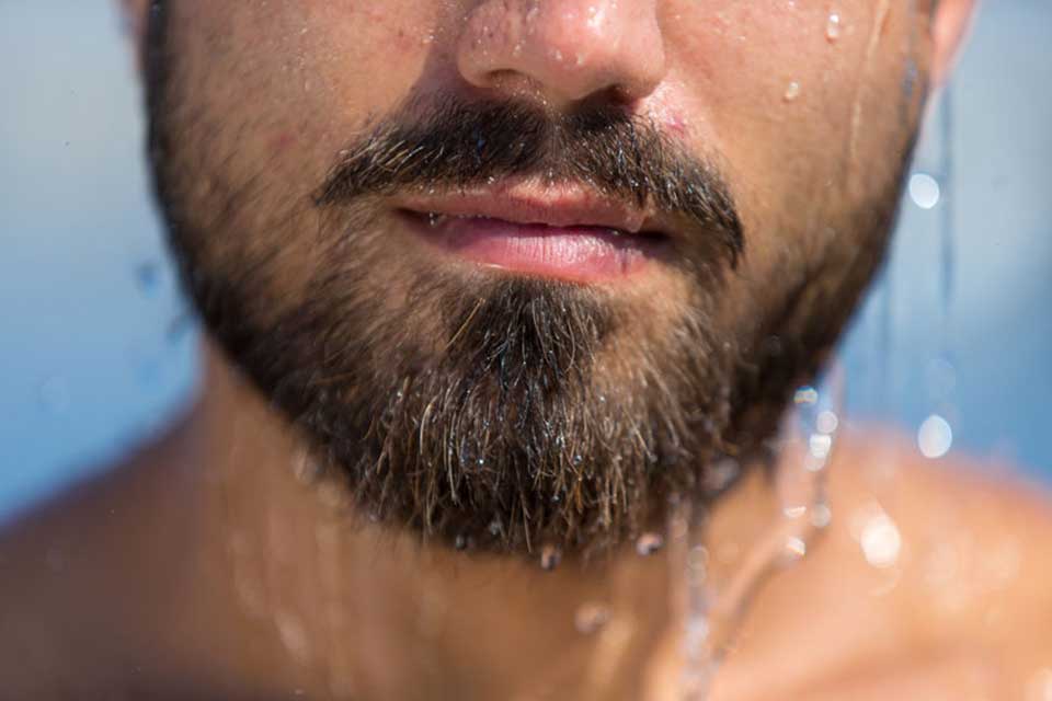A bearded man with moisturized skin.