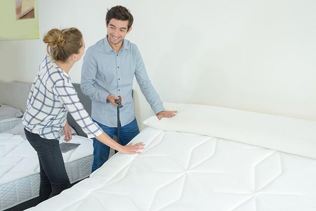 A couple examining the best mattresses.