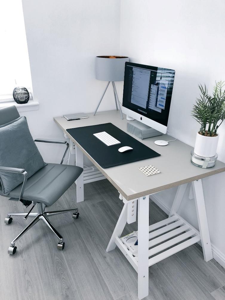 A white home office desk with a chair and a plant.