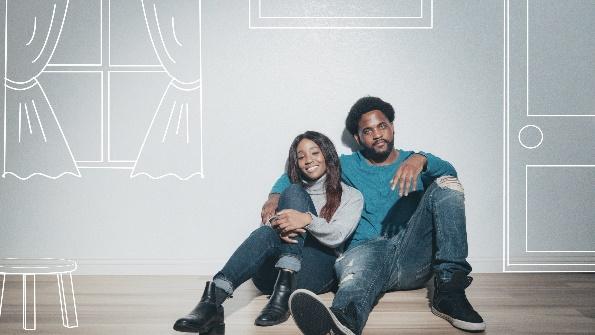 A couple sitting on the floor in a rented room.