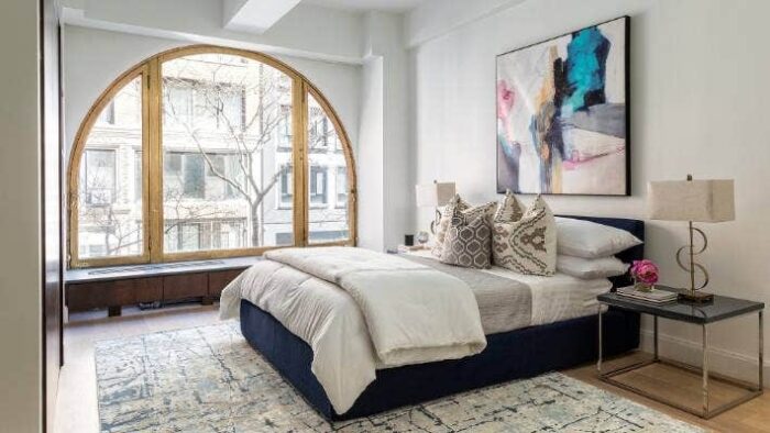 Bedroom ideas with an arched window and a blue rug.