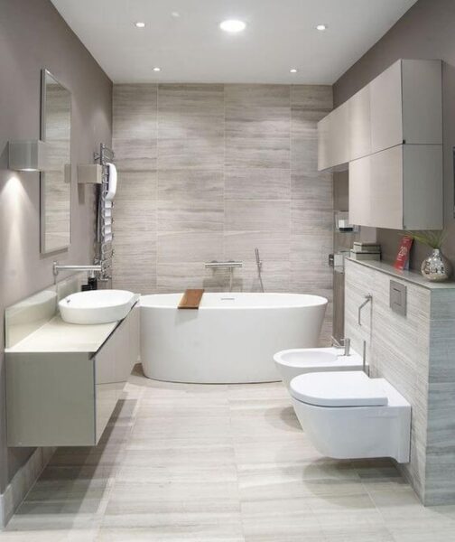 Ideas for renovating a modern bathroom with a bathtub, sink and toilet.