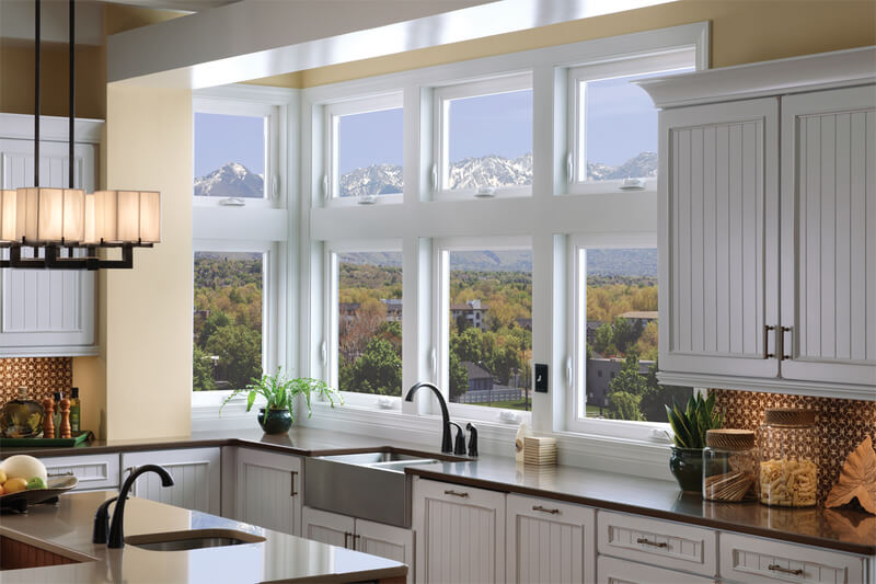 A kitchen with casement windows overlooking a mountain range.