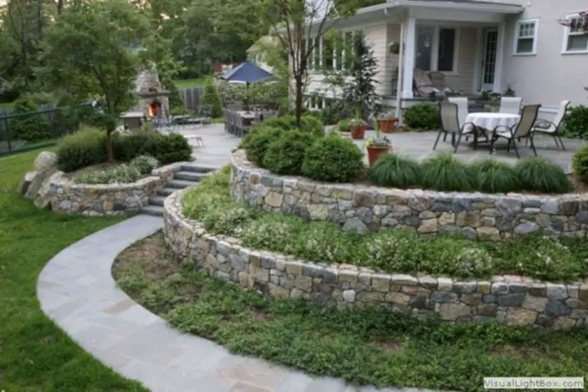 A backyard with a stone retaining wall.