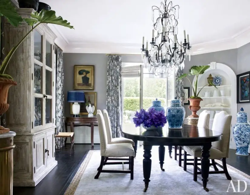 A dining room with a chandelier and blue vases.