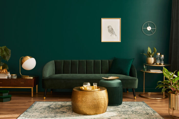 A renovated living room with green walls and gold accents.