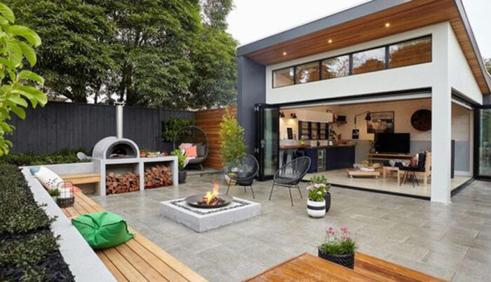 A modern backyard renovation with a fire pit.