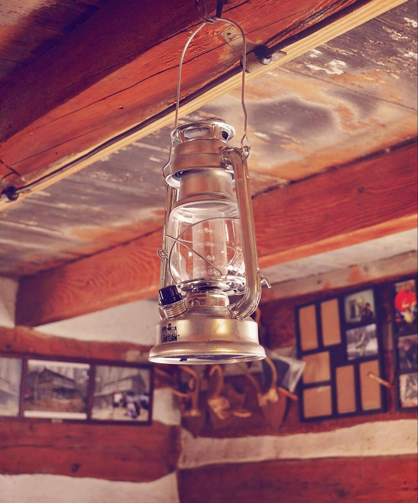 A rustic lantern hanging from the ceiling of a cabin.