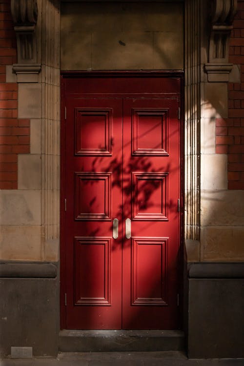 The best red door in front of a brick building.