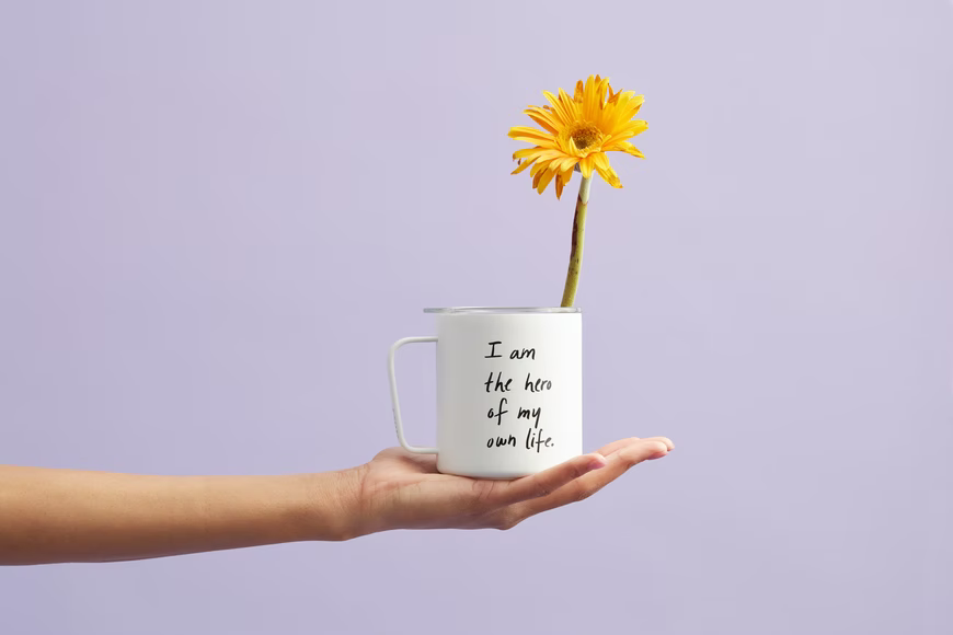 A hand holding a mug with a yellow flower in it while providing 10 Tips on being the best version of yourself.