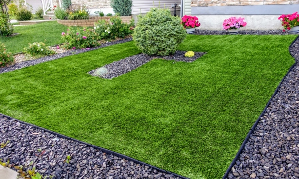 Artificial grass providing low-maintenance landscaping in the front yard of a home.