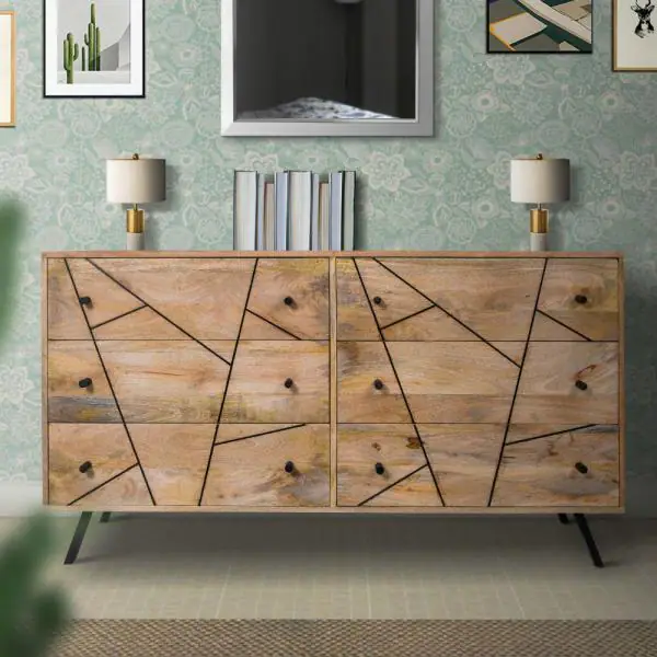 A wooden chest of drawers in a room with a green wall.