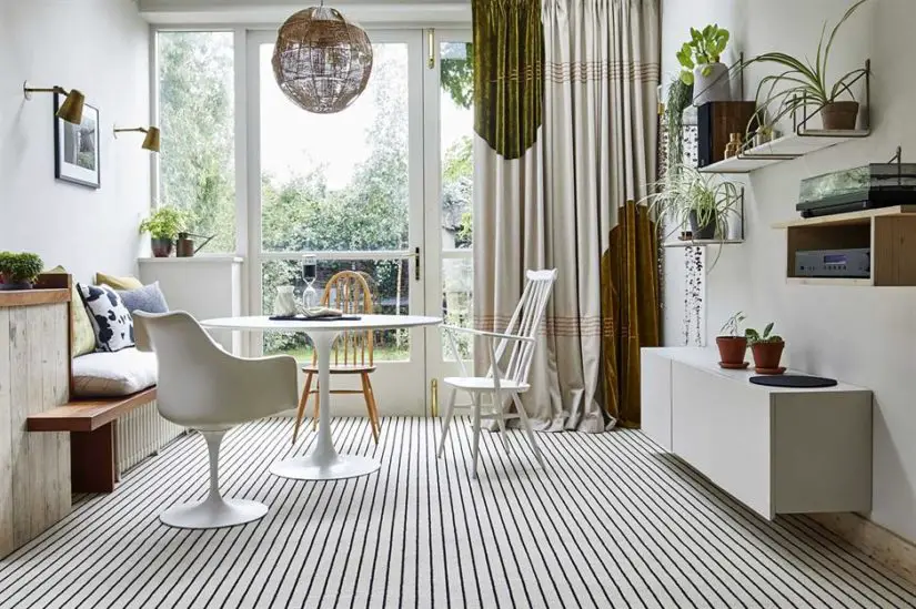 A living room with a striped floor and a table.