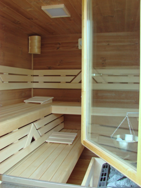 A right sauna with wooden benches and a glass door.