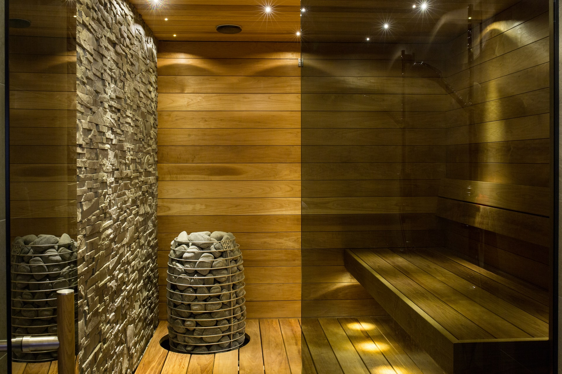 A sauna room with wooden walls and a stone bench that requires maintenance.
